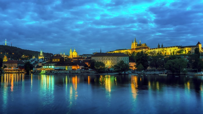 Prague cityscape with river and castle at dusk
