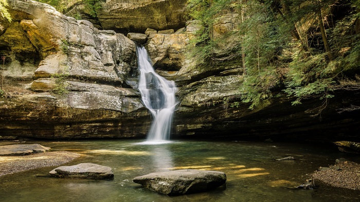 Waterfall cascading into a pool in a rocky gorge