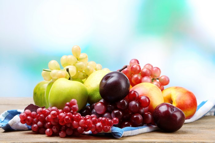 Assortment of Fresh Fruits: Grapes, Apples, Plums, and Peaches