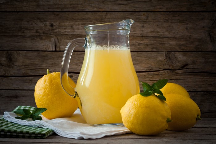 Lemonade in a jug with lemons and mint