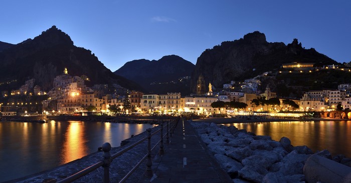 Amalfi, Italy coast at night with illuminated buildings and mountains