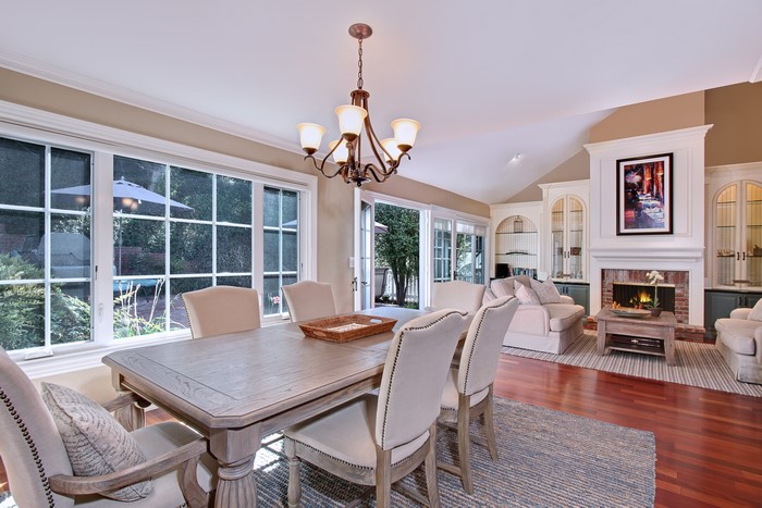 Dining room with chandelier and living room with fireplace