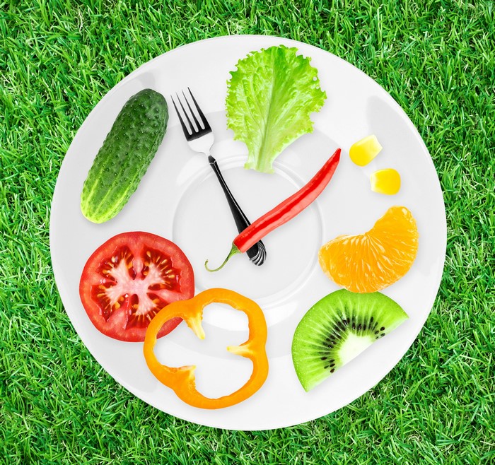 Vegetables and fruit arranged on a plate like a clock