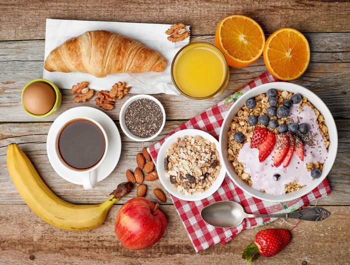 Breakfast with Muesli, Croissant, Coffee, and Fruits