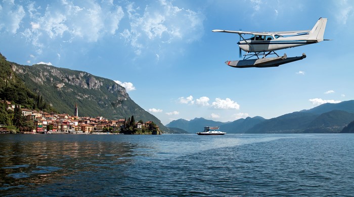 Seaplane flying over a lake with Varenna, Italy in the background