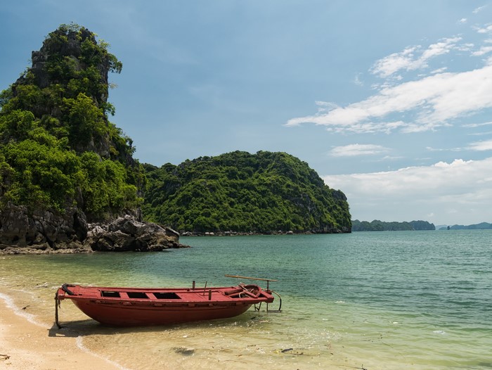 Red boat on the beach in Ha Long Bay, Vietnam
