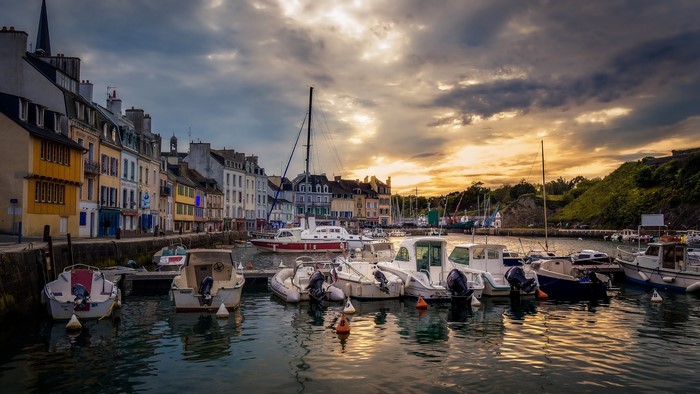 Boats in a harbor with buildings in Le Palais, Brittany, France