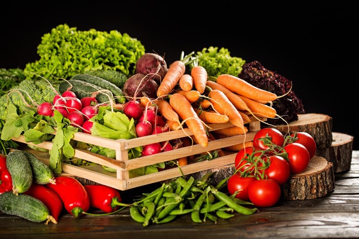 Assortment of fresh vegetables in a wooden crate