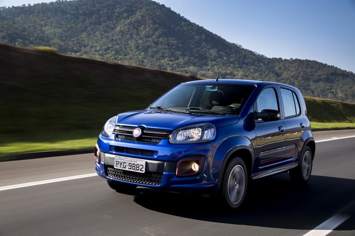 Blue Fiat Uno Sporting driving on a road