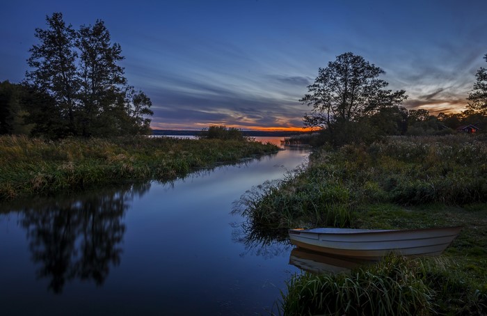 Boat on a river at sunset in Sweden