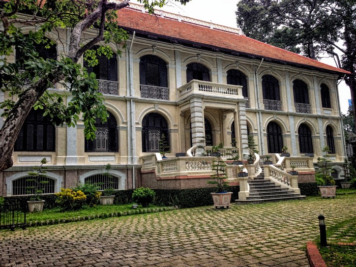 Colonial building with stairs and trees in Ho Chi Minh City, Vietnam