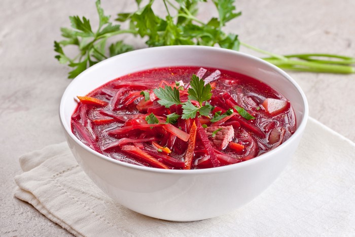 Bowl of Borscht soup with parsley garnish