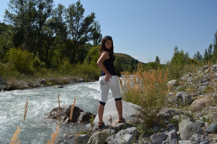 Woman Standing on Rocks by Rapid River