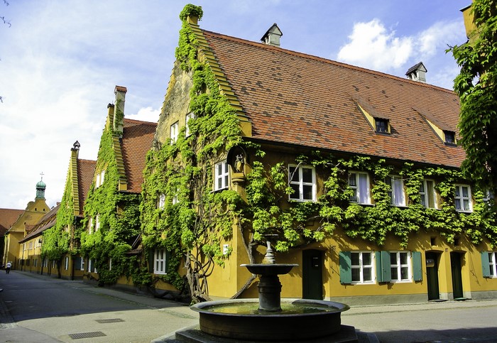 Fountain in front of ivy-covered houses in Augsburg, Germany