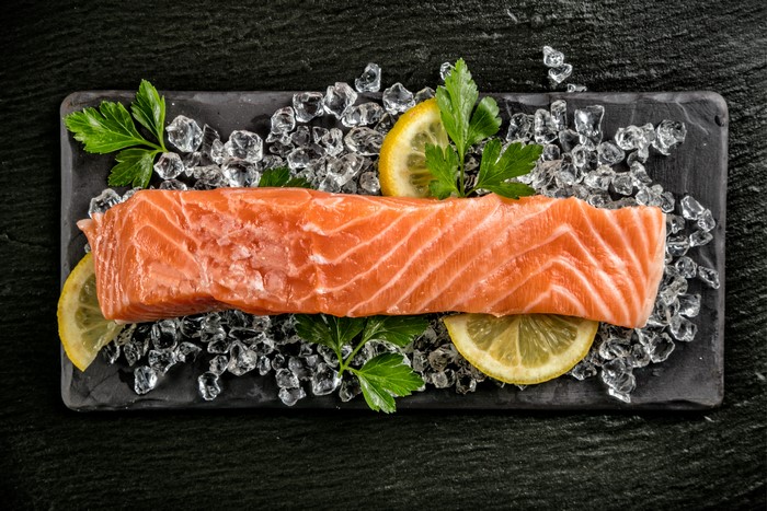 Salmon fillet on ice with lemon and parsley