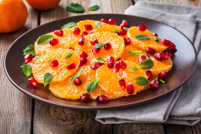 Orange slices with pomegranate seeds and mint