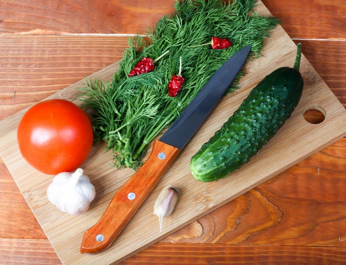 Knife, Dill, Tomatoes, Cucumbers, and Garlic on Cutting Board