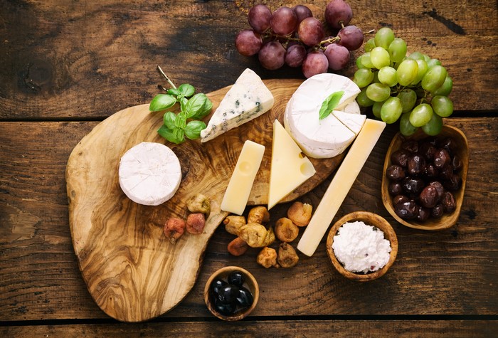 Cheese board with grapes, olives, and figs