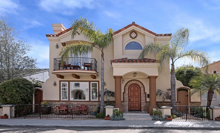 Spanish Style House with Palm Trees and Fence