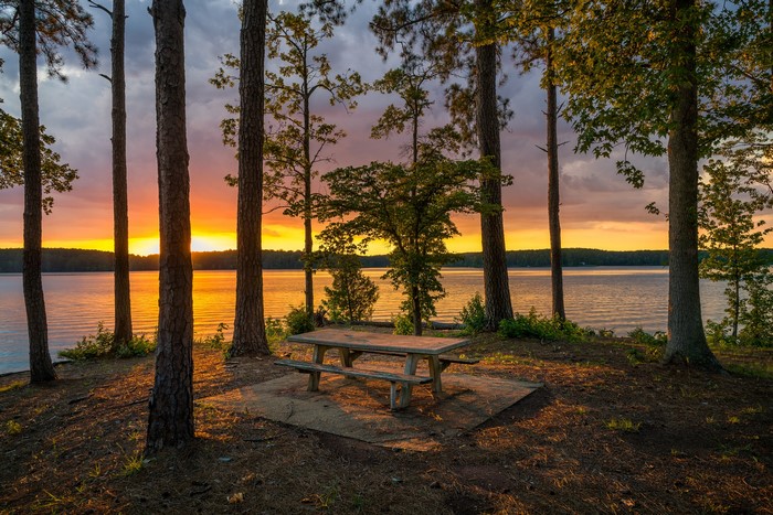 Picnic table by lake at sunset in West Point Lake, Georgia