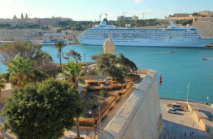 Cruise liner docked in Valetta, Malta harbor with city skyline