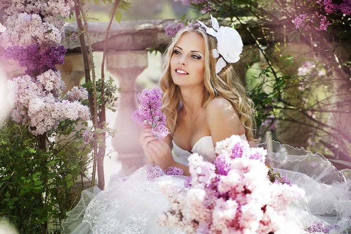 Blonde bride in white dress with lilac flowers