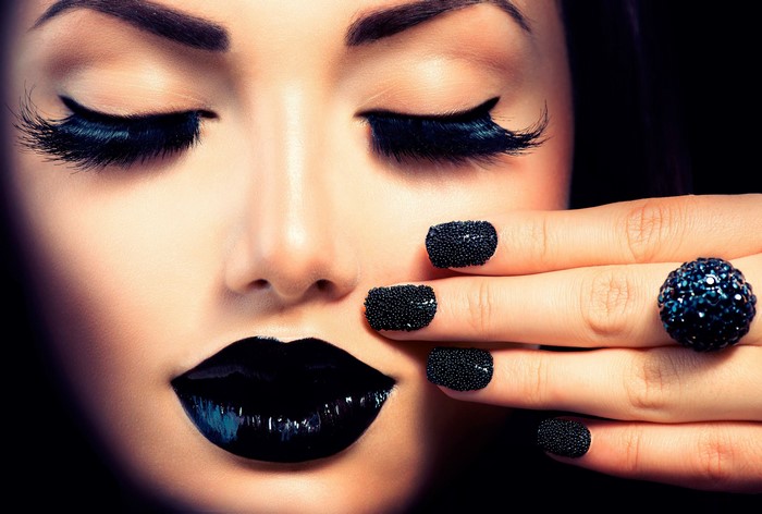 Woman with black lipstick, eyelashes, and nails