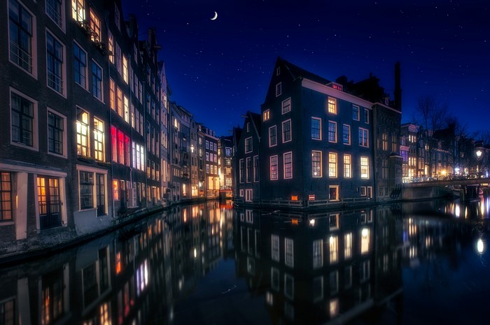Amsterdam canal houses at night with moon and stars