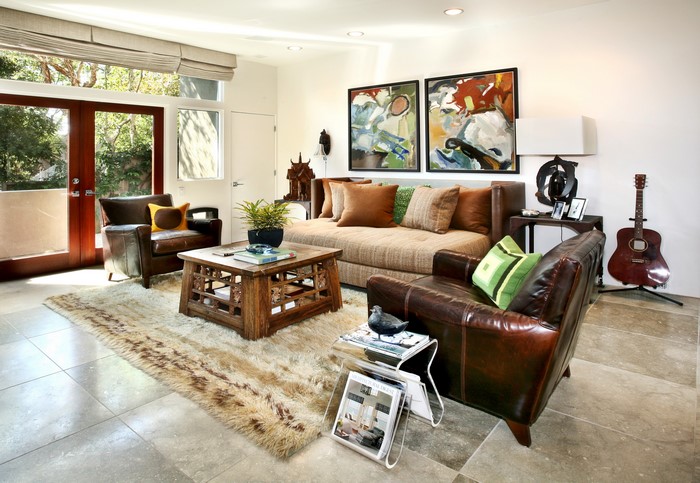 Living room with sofa, armchairs, coffee table, and guitar
