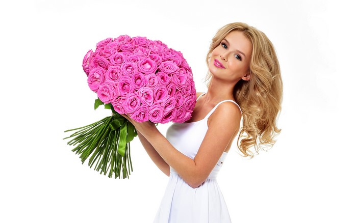 Blonde woman holding a large bouquet of pink roses