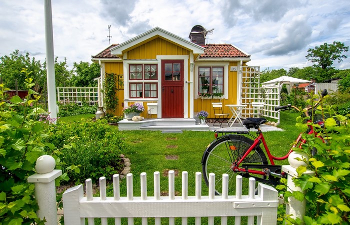 Yellow house with red door and bicycle in Uppsala, Sweden