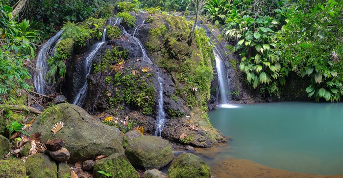 Waterfall in a tropical forest with mossy rocks