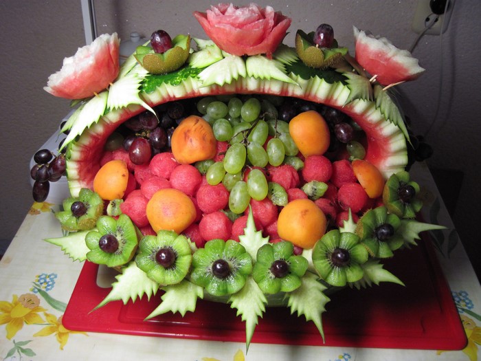 Fruit basket carved from watermelon with grapes, kiwi, and watermelon balls