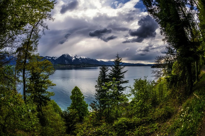 Lake Thun with snow-capped mountains and stormy clouds in Switzerland