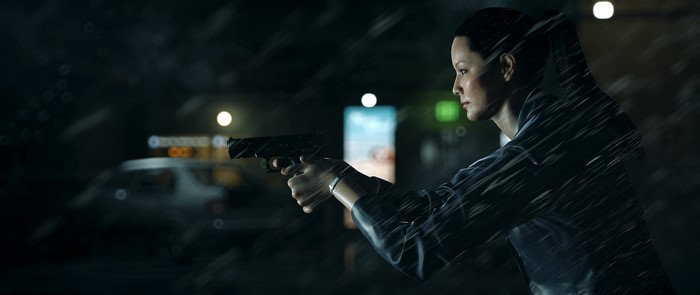 Woman with pistol in the rain at night