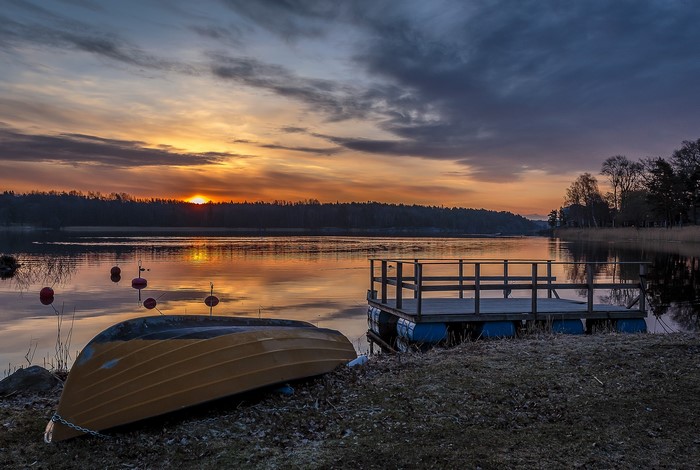 Boat and dock at sunset on a lake in Sweden