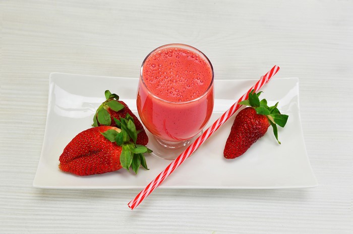 Strawberry juice with strawberries on a plate
