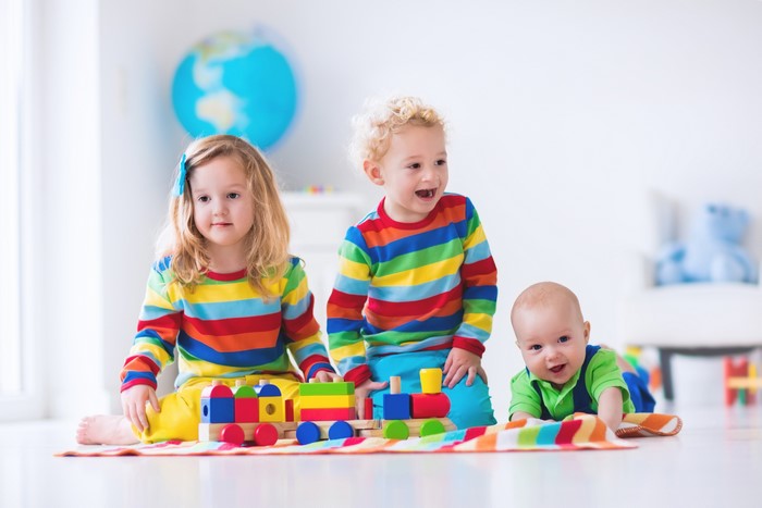 Three Children Playing with a Toy Train