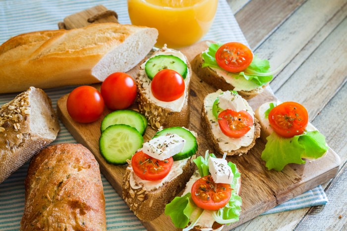 Bread with cream cheese, tomatoes, cucumbers, and lettuce