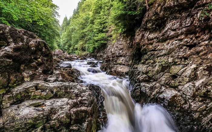 Waterfall in a rocky gorge with trees in Wales