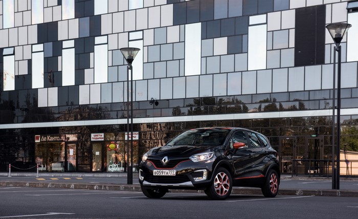 Black Renault Kaptur parked in front of a modern building