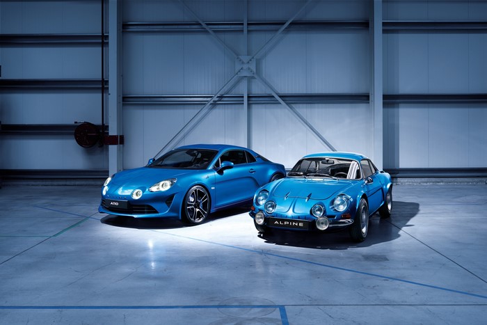 Two blue Alpine cars in a warehouse