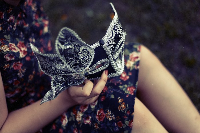 Close-up of a person holding a decorative mask