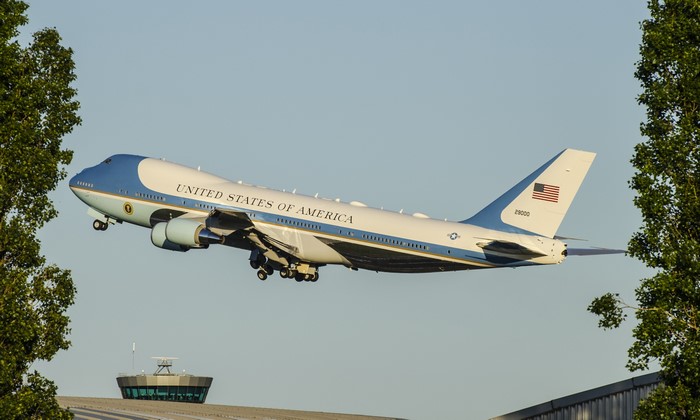 Air Force One taking off near an airport control tower