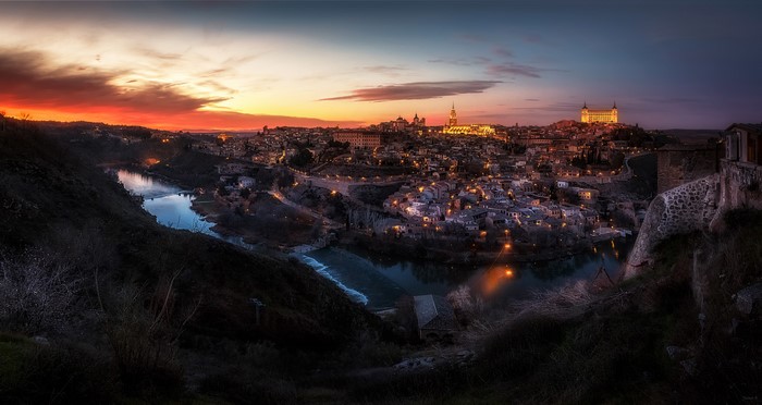 Toledo, Spain at sunset with river and city lights