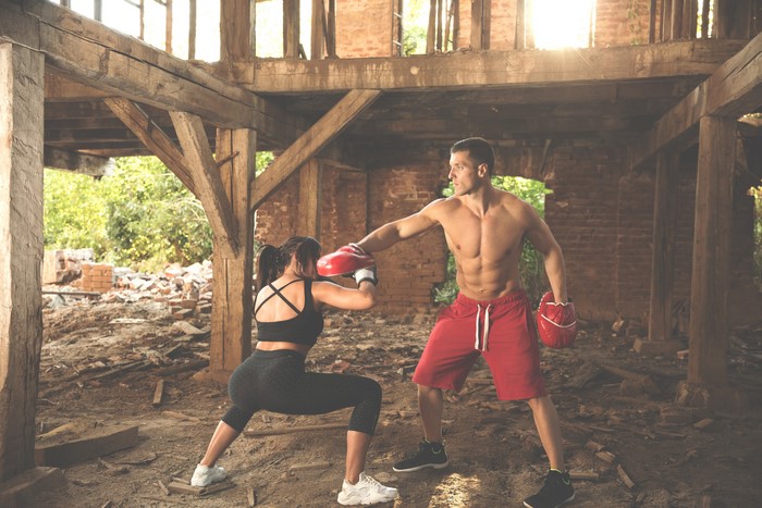 Two boxers training in a ruined building