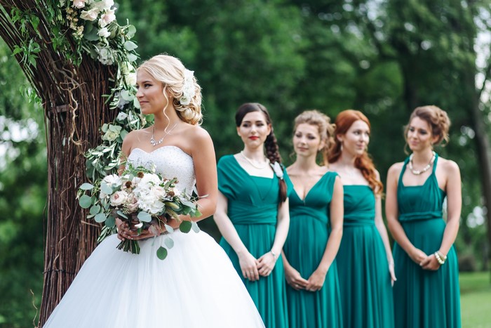 Bride and bridesmaids in teal dresses with bouquets