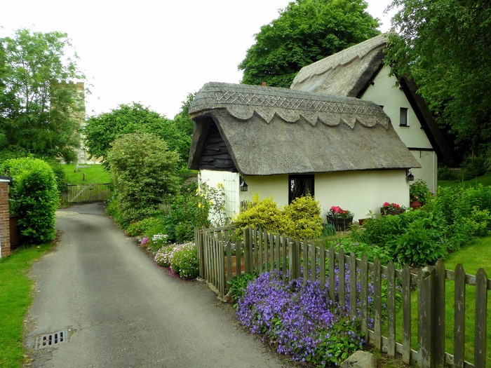 Thatched cottages and a church tower in Mill End, England