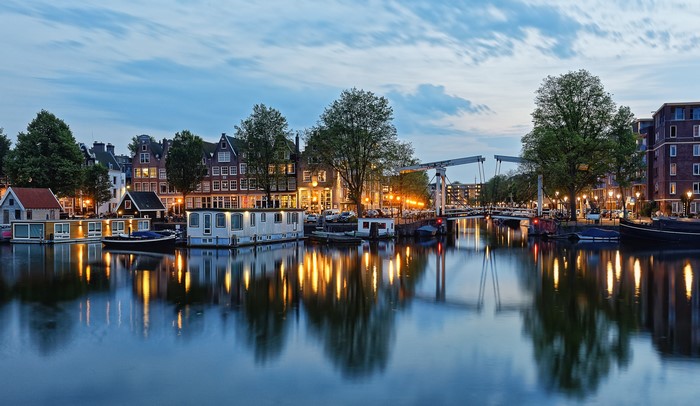 Amsterdam canal with houses and bridge at dusk