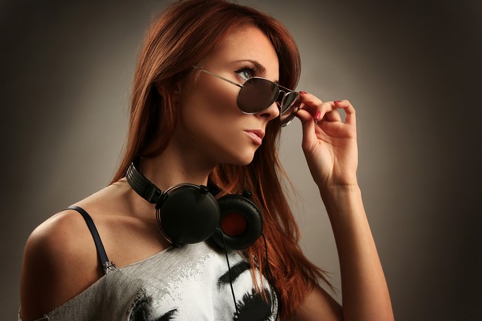 Redhead girl with sunglasses and headphones